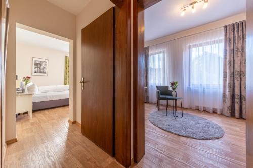 a bedroom with a door leading to a room with a bed at Landhotel Salmen in Oberkirch