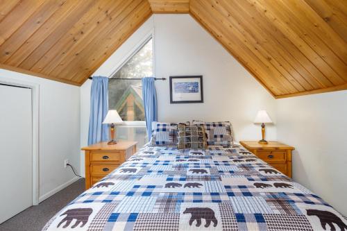 a bedroom with a bed and a window with blue curtains at Snowbird Chalet #8 in Girdwood