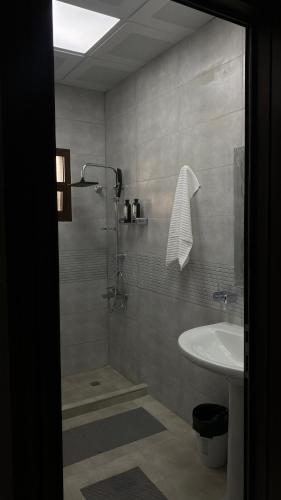 a bathroom with a shower and a sink at Alhara Lodge استراحة الحارة in Hatta