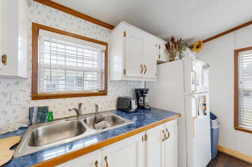 a kitchen with a sink and a refrigerator at Assateague Point Vacation in Berlin