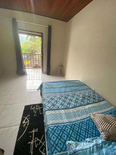 Duas camas num quarto com uma janela em Apartamento área central em Ubatuba