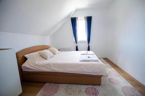 a bedroom with a bed with a window and a rug at Ventum Luxury House Bjelasnica in Sarajevo