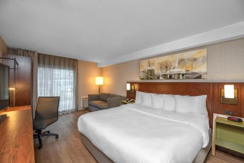 a hotel room with a large bed and a desk at Comfort Inn in Hamilton