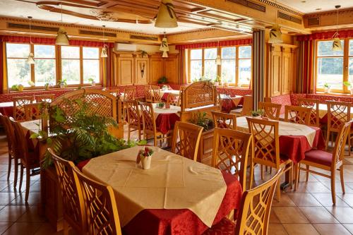 una sala da pranzo con tavoli, sedie e finestre di Gasthof Schattleitner a Brückl