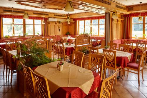 un comedor con mesas, sillas y ventanas en Gasthof Schattleitner, en Brückl