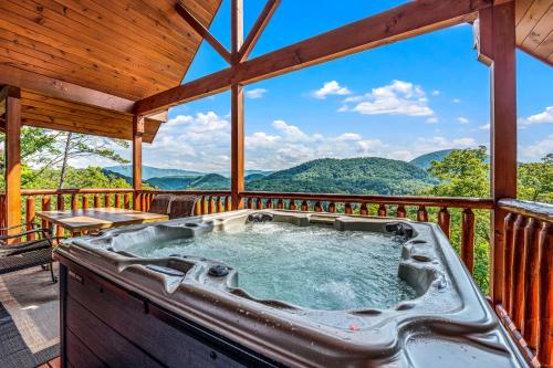 a hot tub on a deck with a view of mountains at Peace in the Valley - Mtn VIEWS w/HotTub, GameRoom, Theatre, Arcade in Sevierville