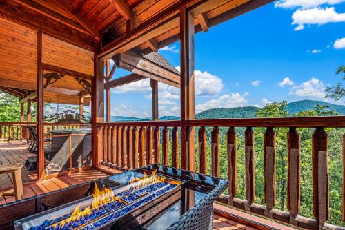 a screened in porch with a hot tub on the deck at Peace in the Valley - Mtn VIEWS w/HotTub, GameRoom, Theatre, Arcade in Sevierville