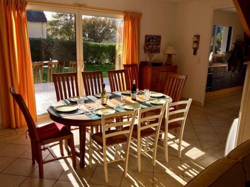 - une table à manger et des chaises dans une cuisine avec une table et des chaises dans l'établissement Les Joncades - Maison de vacances, à Saint-Gildas-de-Rhuys