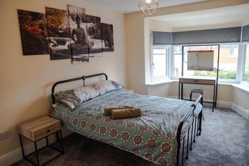 a bedroom with a bed and a desk and a window at Spacious Family Home Minutes from the Beach in Blackpool