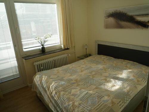 een slaapkamer met een bed en 2 ramen bij 7-9, Marienstr, sehr strandnah, Südbalkon mit kleinem Seeblick, 2 Zi in Westerland