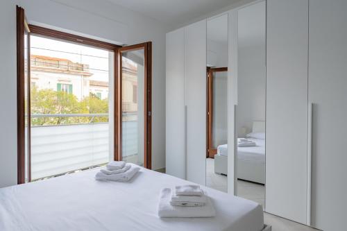 Dormitorio blanco con cama y ventana grande en Pantaleone Rapino 56 - YourPlace Abruzzo, en Ortona