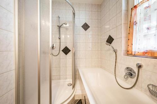 a bathroom with a shower and a bath tub at Gästehaus Wiesengrund & Apart Sporer in Mayrhofen