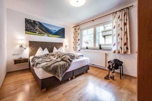 1 dormitorio con cama y ventana en Gästehaus Wiesengrund & Apart Sporer, en Mayrhofen