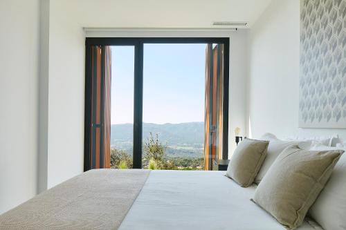 una camera da letto con un letto bianco e una grande finestra di Casa Pere Costa Brava - by EMERALD STAY a Santa Cristina d'Aro