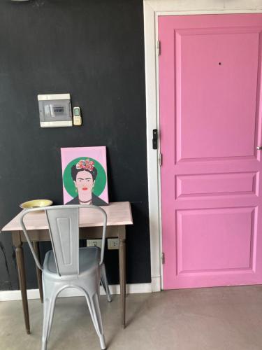 a pink door in a room with a table and chair at Viví Home in Mar del Plata