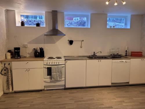 Kulltorp的住宿－Bokskogens Guesthouse，厨房配有白色橱柜和炉灶烤箱。