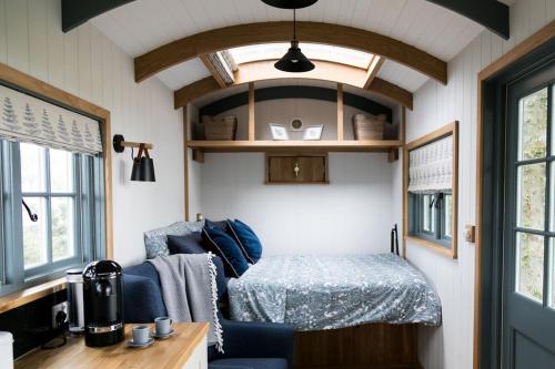 um pequeno quarto com uma cama numa pequena casa em Skylark Shepherds Hut em Bath