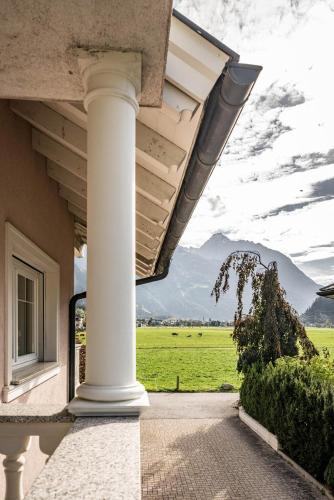 a white column on a house with a view of a field at Gästehaus Wiesengrund & Apart Sporer in Mayrhofen
