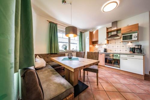 a kitchen and living room with a table and a couch at Gästehaus Wiesengrund & Apart Sporer in Mayrhofen