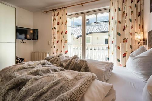 a bedroom with a bed and a large window at Gästehaus Wiesengrund & Apart Sporer in Mayrhofen
