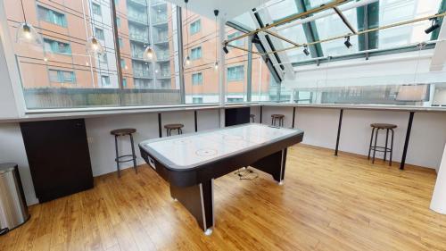 a ping pong table in a large room with stools at Wilmslow Park Manchester in Manchester