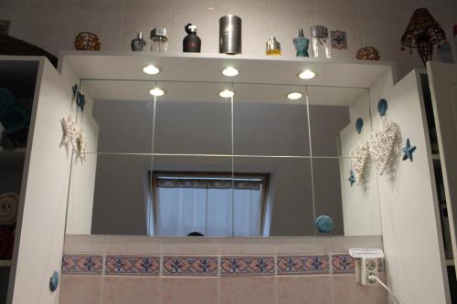 a bathroom with a large mirror on the wall at Chambres d'Hôtes Les Mésanges in Saint-Martin-lez-Tatinghem
