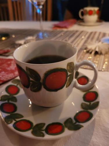 a cup of coffee on a plate on a table at Bokskogens Guesthouse in Kulltorp
