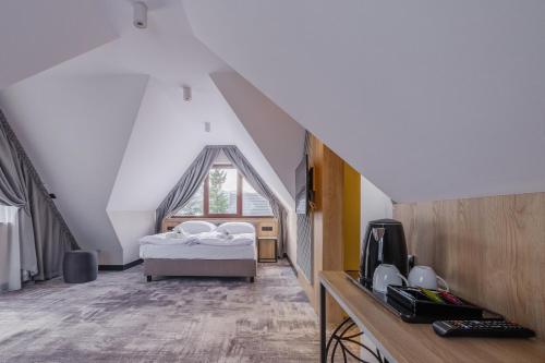 um quarto com uma cama num sótão em Wielka Krokiew Residence&SPA - Zakopane - JACUZZI, SAUNA, TĘŻNIA SOLANKOWA, SPA, GRILL em Zakopane