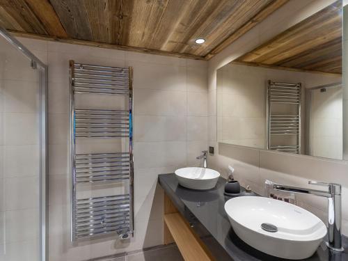 une salle de bain avec un lavabo et un miroir dans l'établissement Duplex Neuf Près des Pistes avec Cheminée, Parking et Wifi Inclus - FR-1-562-72, à Courchevel