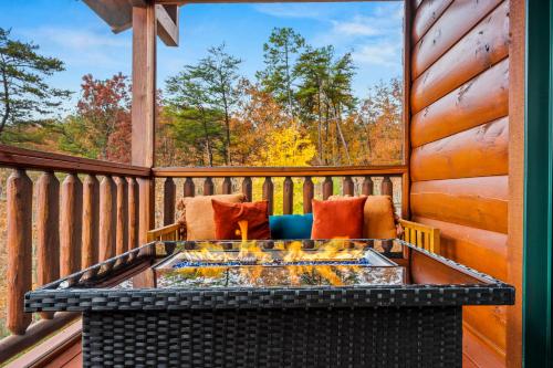 a screened in porch with a fire pit on a deck at Peace in the Valley - Mtn VIEWS w/HotTub, GameRoom, Theatre, Arcade in Sevierville