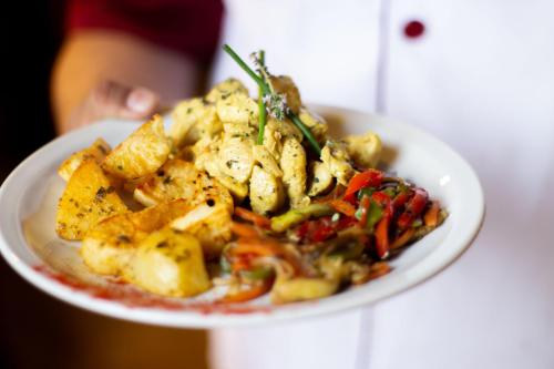 a plate of food with potatoes and vegetables on a table at Vieja Posada Hotel Histórico in Cafayate