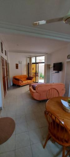 uma grande sala de estar com um sofá e uma cama em Busy Bee Apartments em Kololi