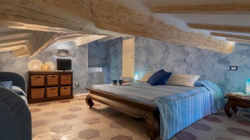 a bedroom with a bed with a blue comforter at VILLA CORALLINA 12, Emma Villas in Marina di Bibbona