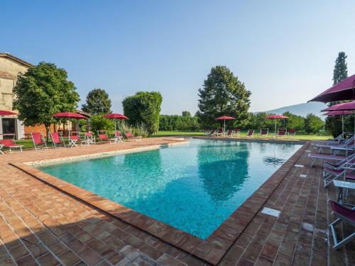 a large swimming pool with chairs and umbrellas at Foresteria Il Giardino di Fontarronco in Alberoro