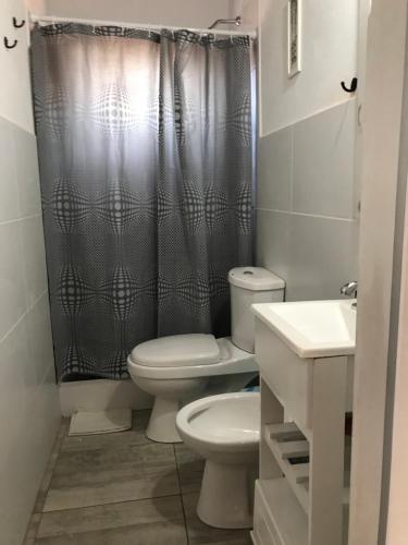 a bathroom with a toilet and a shower curtain at India del mar II in Chapadmalal