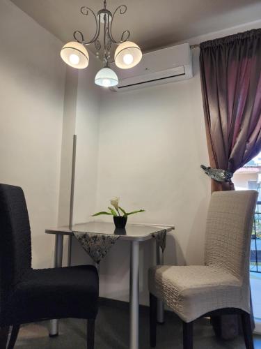 a dining room table with two chairs and a chandelier at Apartments Ohrid Lake in Ohrid