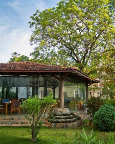 a house with a tree in the yard at Anantamaa Hotel in Trincomalee