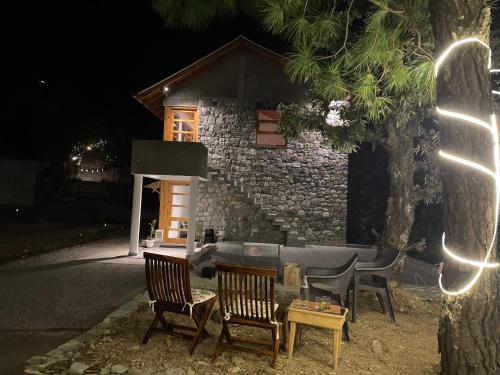 a group of chairs sitting in front of a building at Bagar Trails in Nainital