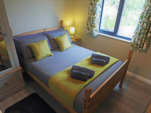 a bedroom with a bed with two pillows on it at Primrose Lodge - Uk13447 in Halwill