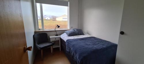 a small bedroom with a bed and a window at Hátún in Glaumbær