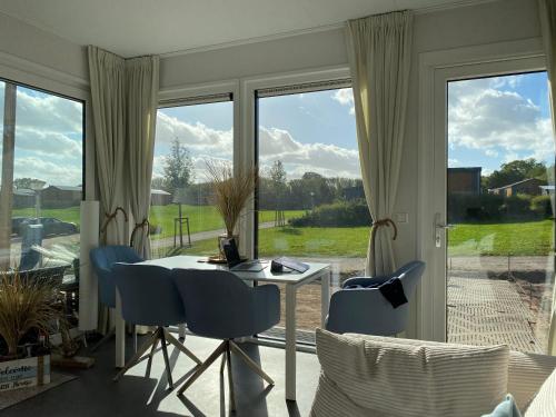 een woonkamer met een tafel en stoelen en een raam bij Seaside Beach House Chalet - Seeparx Süsel in Süsel