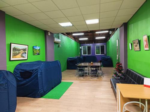 a room with green walls and a table and chairs at 博愛泊旅讀心境 in Hualien City