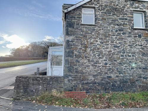 a stone building with a door on the side of a road at Taylor Way in Aberystwyth