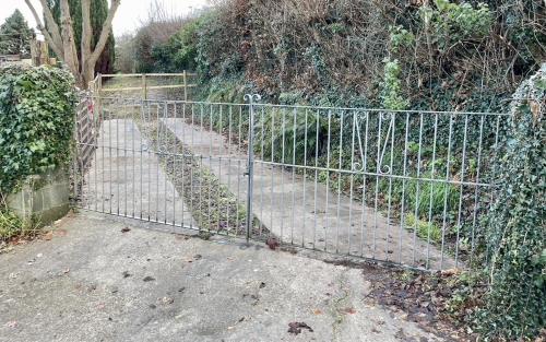 un cancello di metallo di fronte a un giardino di Taylor Way ad Aberystwyth