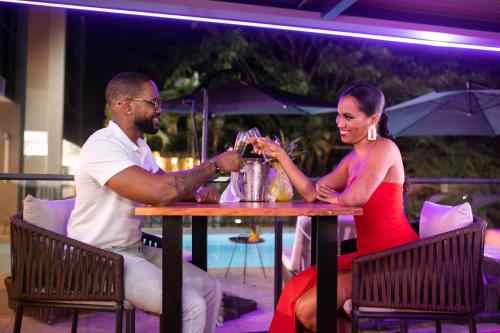 a man and a woman sitting at a table at Karibea Squash Hôtel in Fort-de-France