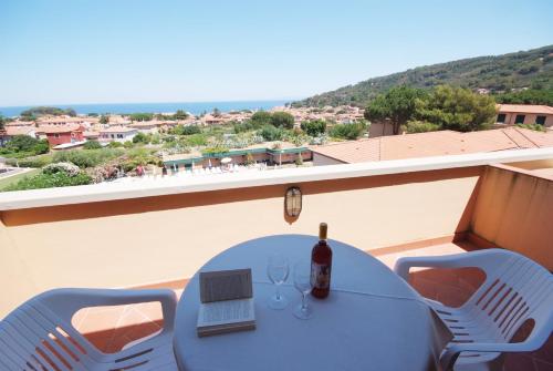 a table with a bottle of wine on a balcony at Hotel Residence Isola Verde in Marciana Marina