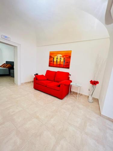 um sofá vermelho numa sala de estar com um quadro na parede em Casa Aurora em Bari