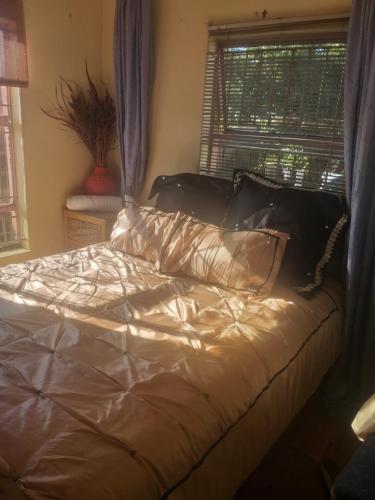 een bed in een slaapkamer met een raam bij Feel at home stay in Bloemfontein