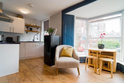 a kitchen with a chair and a table and a refrigerator at Stunning 3 bed Home, 5 mins from Margate Beach in Kent