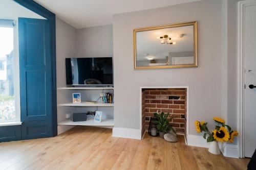 a living room with a blue door and a fireplace at Stunning 3 bed Home, 5 mins from Margate Beach in Kent